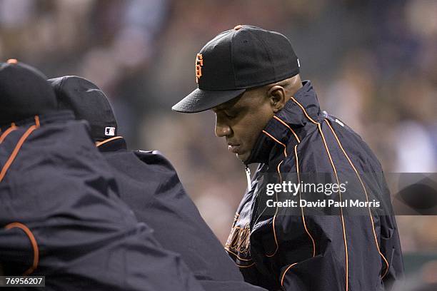 San Francisco Giants left fielder Barry Bonds watches the game from the Giants dugout after a press conference earlier in the day announcing the...