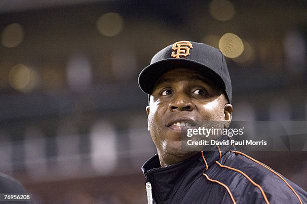 San Francisco Giants left fielder Barry Bonds watches the game from the Giants dugout after a press conference earlier in the day announcing the...