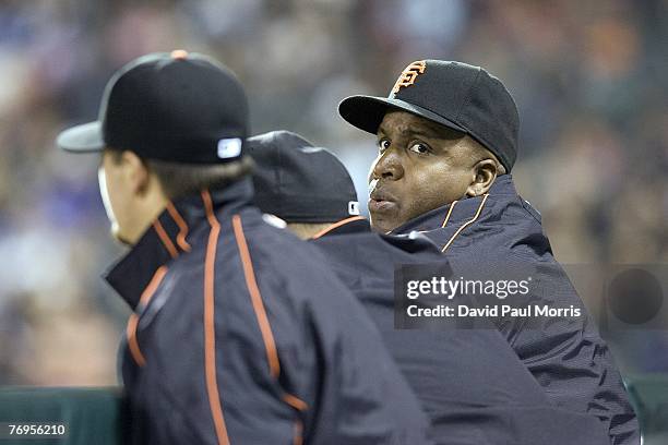 San Francisco Giants left fielder Barry Bonds watches the game from the Giants dugout after a press conference earlier in the day announcing the...