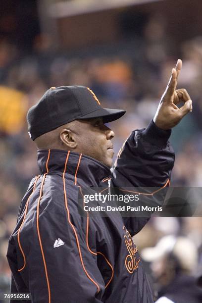 San Francisco Giants left fielder Barry Bonds watches the game from the Giants dugout after a press conference earlier in the day announcing the...