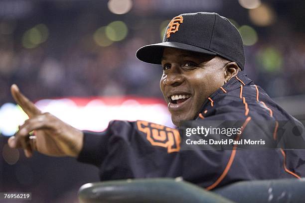 San Francisco Giants left fielder Barry Bonds watches the game from the Giants dugout after a press conference earlier in the day announcing the...