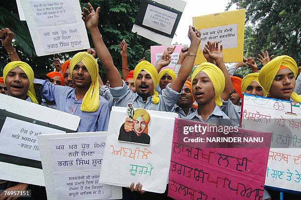 Indian Sikh youths wearing yellow turbans 'dastar' shout slogans and wave placards as they take part in a procession in Amritsar, 22 September 2007,...