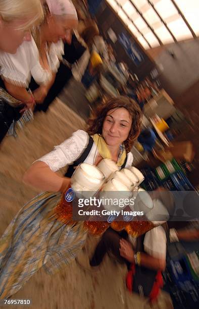 Waitress serves hugs of beer in the Hofbraeuhaus tent after the ceremonial opening of the Oktoberfest beer festival on September 22, 2007 in Munich,...