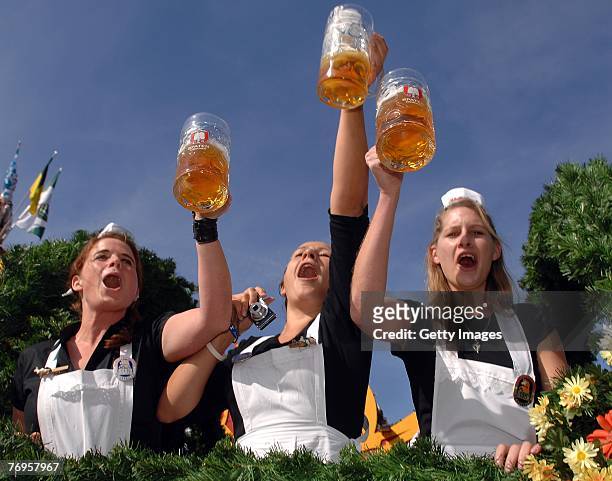 Waitresses hold hugs of beer while riding on the breweries horsecarduring the ceremonial opening of the Oktoberfest beer festival on September 22,...