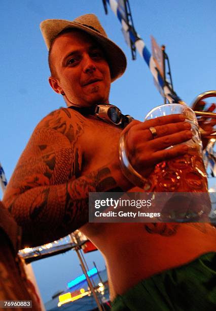 Young man holding a mug of beer at the Oktoberfest beer festival on the evening of September 22, 2007 in Munich, Germany. During the Oktoberfest,...