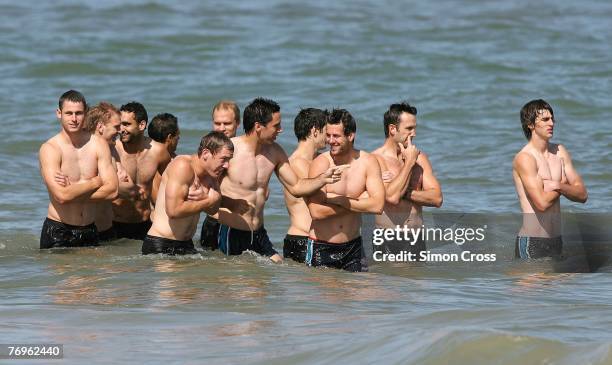 Power players stand in the sea during the Port Adelaide Power AFL recovery session at Grange Beach on September 23, 2007 in Adelaide, Australia.