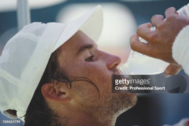Australian tennis player Patrick Rafter pictured drinking from a bottle of water during progress to reach the third round of the men's singles tennis...