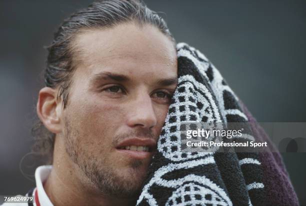 Australian tennis player Patrick Rafter pictured wiping his face with a towel during competition to reach the fourth round of the Men's Singles...