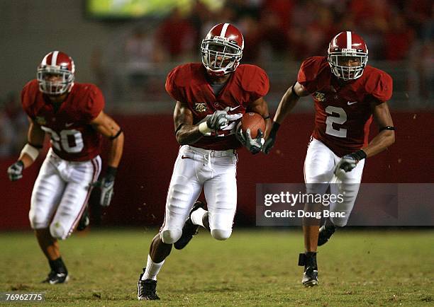 Rashad Johnson of the Alabama Crimson Tide, flanked by teammates Marcus Carter and Simeon Castille, returns an interception against the Georgia...