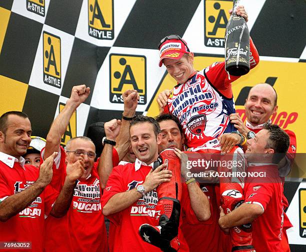 Casey Stoner of Australia, Ducati Marlboro team, is lifted by his team members as he celebrates his first world motorcycling championship title at...