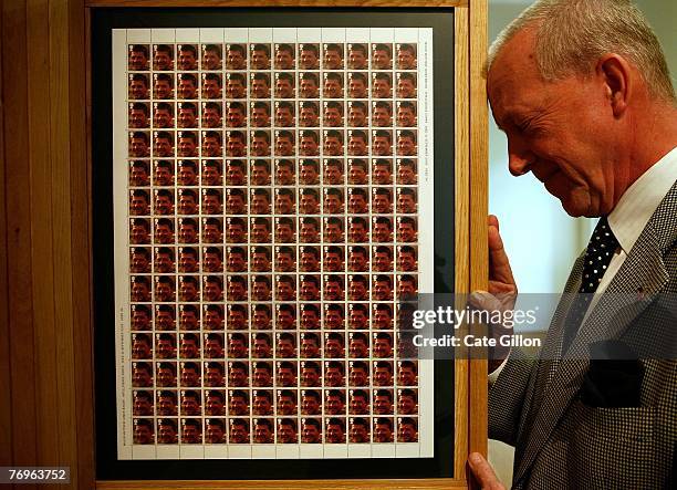 Mr. Roger Bacon stands beside facsimile postage stamps displaying his son's photograph as part of Steve McQueen's work 'Queen and Country' on...