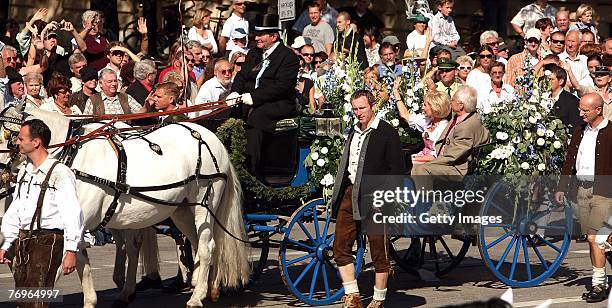 Edmund Stoiber , Bavaria's outgoing State Governor and his wife Karin, wave from a coach during the Costume and Riflemen's Parade on September 2007...