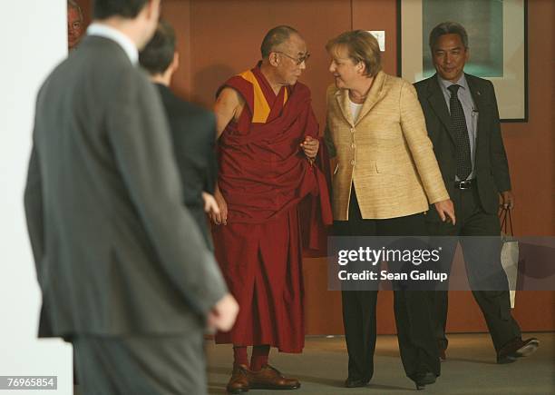 German Chancellor Angela Merkel walks with the Dalai Lama after private talks at the Chancellery September 23, 2007 in Berlin, Germany. China has...