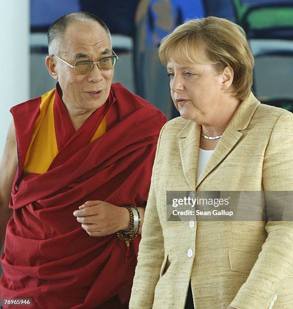 German Chancellor Angela Merkel walks with the Dalai Lama after private talks at the Chancellery September 23, 2007 in Berlin, Germany. China has...