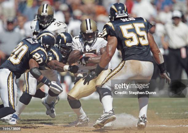 Joe Horn, Wide Receiver for the New Orleans Saints is tackled by Gerald Dixon, Mike Dumas and Junior Seau of the San Diego Chargers during their...