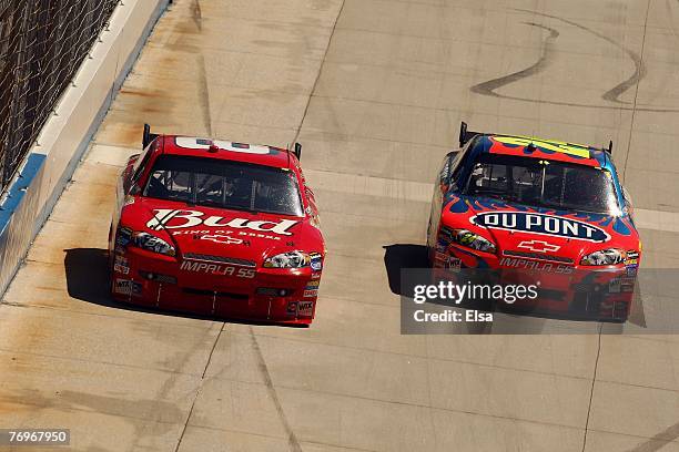 Dale Earnhardt Jr., driver of the Budweiser Chevrolet, drives alongside Jeff Gordon, driver of the DuPont Chevrolet, during the NASCAR Nextel Cup...