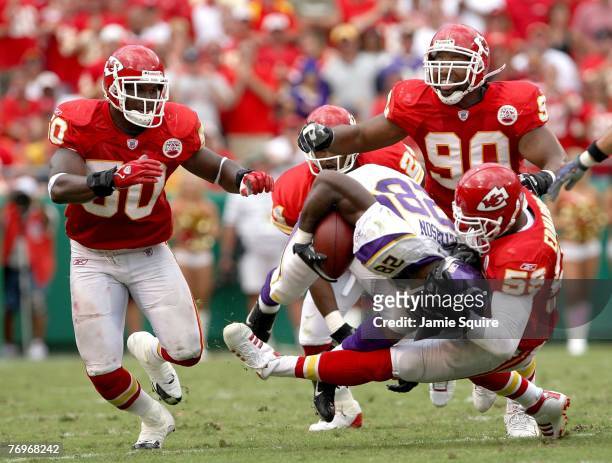 Adrian Peterson of the Minnesota Vikings is tackled by Donnie Edwards, Napoleon Harris and Turk McBride of the Kansas City Chiefs during the 2nd half...