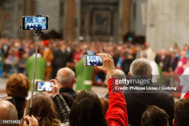 visirors taking cell phone pictures in saint peters basilica, rome. italy.  - basilika stock pictures, royalty-free photos & images