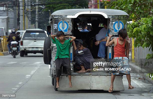 Filipino street children hang on to a passenger jeep as they roam the streets of Manila, 24 September 2007. Child neglect and abuse is a growing...