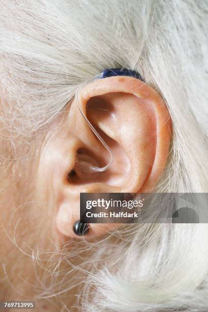 close-up of senior womans ear wearing hearing aid - ear canal stock-fotos und bilder