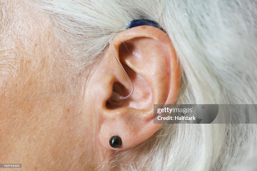 Close-up of woman with gray hair wearing hearing aid