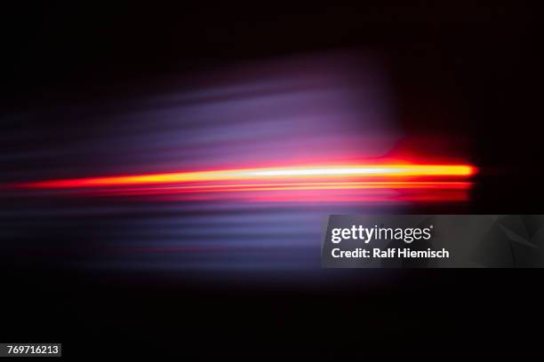 close-up of abstract red light trail against black background - lichterscheinung stock-fotos und bilder