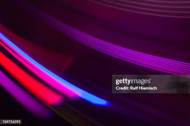 full frame abstract image of vibrant purple and red light trails - black and blue abstract lines background stock-fotos und bilder