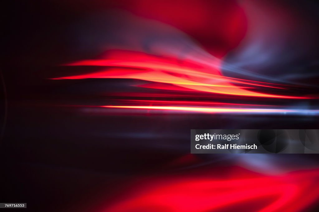 Full frame abstract image of vibrant red light trails