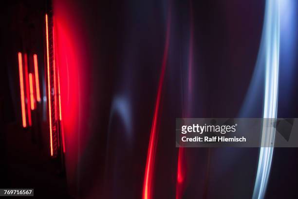 full frame abstract image of red and gray light trails against black background - licht stock-fotos und bilder