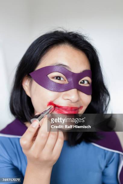 portrait of smiling female superhero wearing red lipstick against gray background - red lipstick smudge stock pictures, royalty-free photos & images