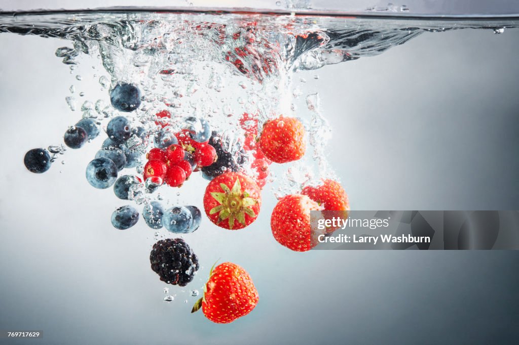 Close-up of various berries in splashing water