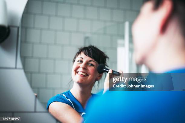 woman doing make-up - espejo fotografías e imágenes de stock