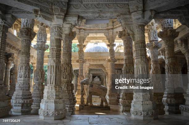 interior view of ranakpur jain temple, ranakpur. carvings and marble columns and a statue of an elephant.  - ranakpur temple fotografías e imágenes de stock