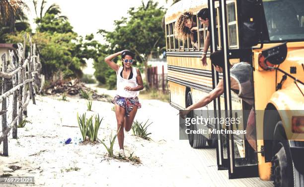 a young woman chasing after a moving school bus. - after run photos et images de collection