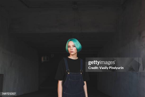 portrait of teenage girl standing in basement - teen attitude stock pictures, royalty-free photos & images