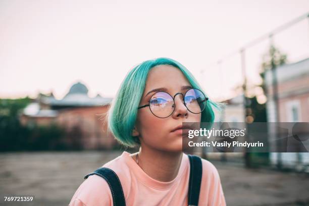 portrait of teenage girl with green dyed hair wearing eyeglasses - depth of field imagens e fotografias de stock