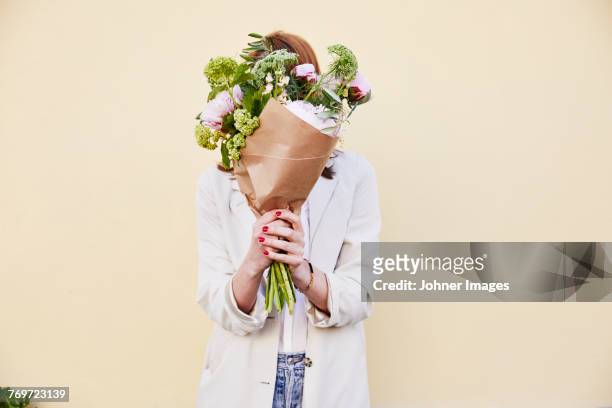 woman holding bouquet of flowers - bouquet fiori foto e immagini stock