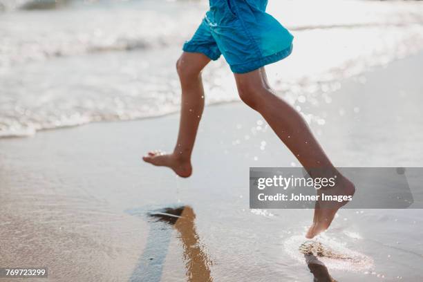 boy running on beach - skane stock pictures, royalty-free photos & images