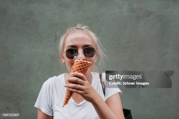 young woman eating ice cream cone - woman ice cream stock pictures, royalty-free photos & images