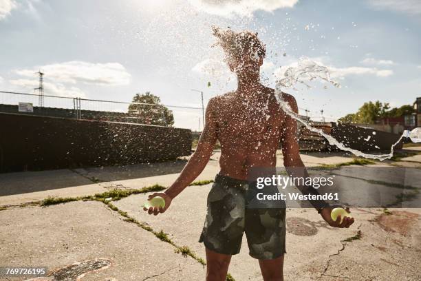 young couple throwing water bags in summer - throwing water stock pictures, royalty-free photos & images