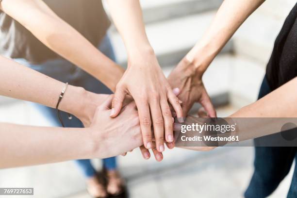 close-up of three women stacking their hands - integridad fotografías e imágenes de stock