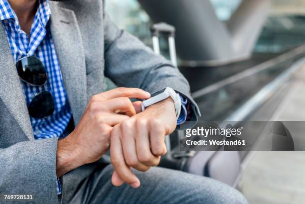 close-up of businessman using his smartwatch in the city - suitcase close stock-fotos und bilder