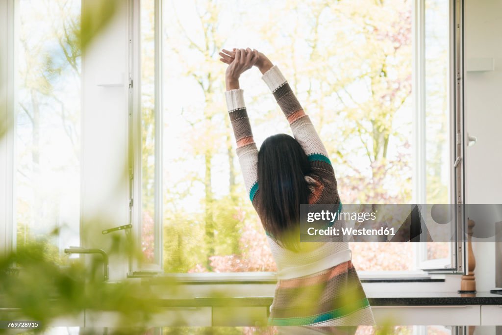 Woman stretching in kitchen