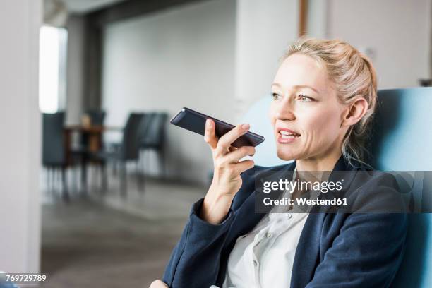 businesswoman using cell phone sending voice mail - woman talking cellphone stock-fotos und bilder