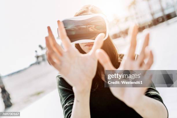 young woman wearing vr glasses outdoors - augmented reality woman stock-fotos und bilder