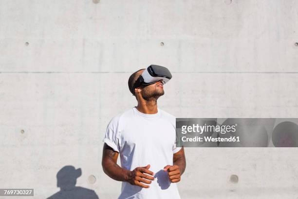man wearing virtual reality glasses - realidad virtual fotografías e imágenes de stock