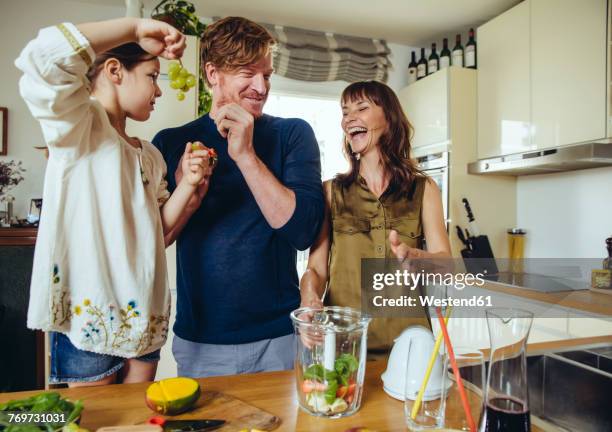 parents and daughter tasting fruit for a smoothie - mum preparing food stock pictures, royalty-free photos & images