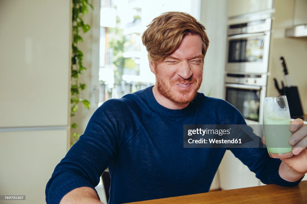 Man making a funny face after drinking a healthy drink