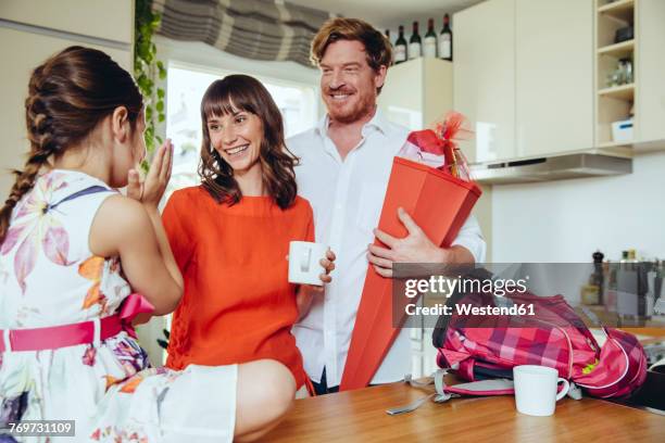 parents presenting school cone to their daughter - first day of school stock-fotos und bilder