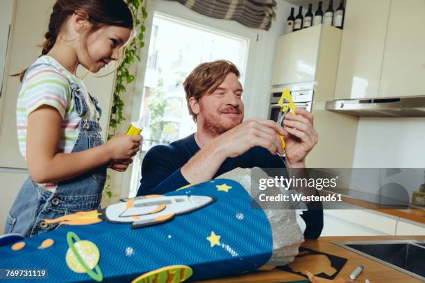 father and daughter creating her space themed school cone at home - first day of school fotografías e imágenes de stock